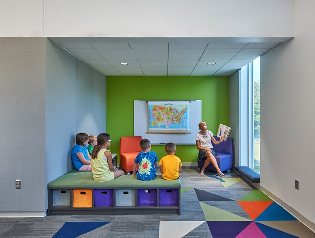 alcove in an elementary school with a teacher reading a book to students