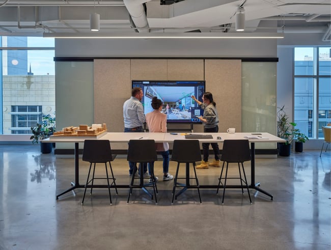 Neumann Monson employees working at a smart board in the Iowa City studio