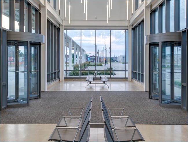 building entrance with revolving doors and rollout mats